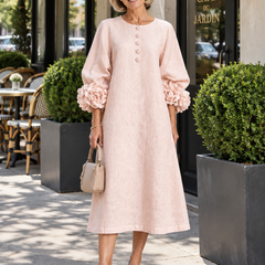 Woman wearing the Ivy blush pink midi dress with rose-cuff sleeves outside a cafe