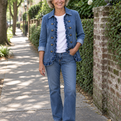 Woman wearing the Ruffelle blue denim ruffled jacket over a white tee and jeans