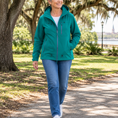 Woman wearing the teal green hooded utility jacket on a park path