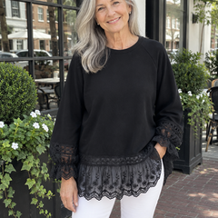 Woman wearing the black lace-panel sweatshirt with white jeans