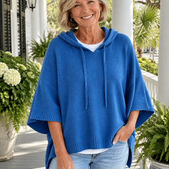 Woman wearing the blue hooded knit poncho sweater on a Charleston porch