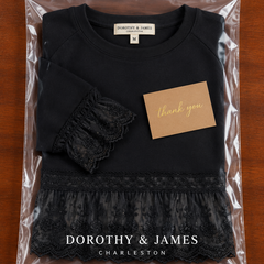 Black lace-panel sweatshirt folded in Dorothy & James Charleston packaging with thank you card