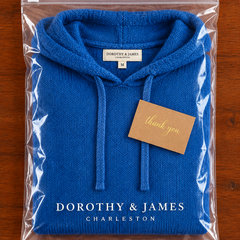 Blue poncho sweater folded in Dorothy & James Charleston packaging with thank you card