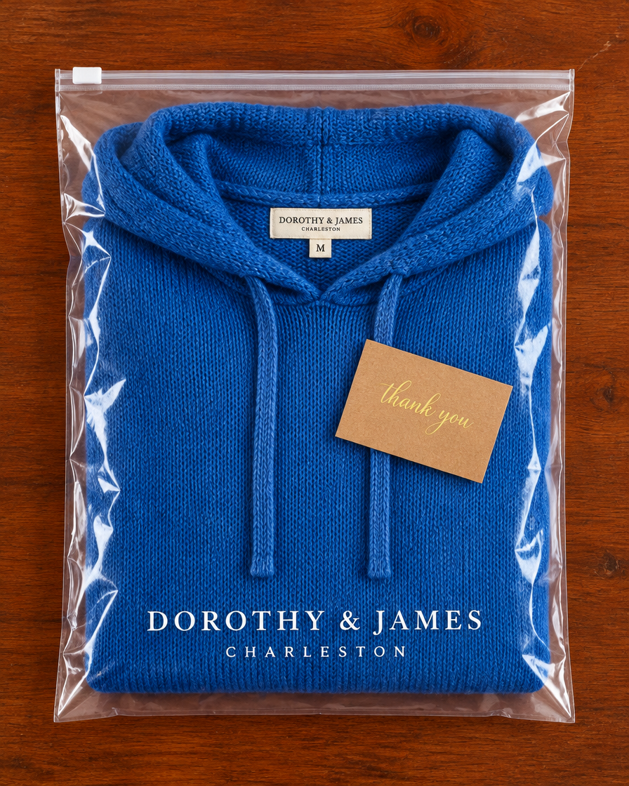 Blue poncho sweater folded in Dorothy & James Charleston packaging with thank you card
