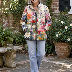 Woman in her 60s wearing the Kaia floral quilted jacket in a garden courtyard